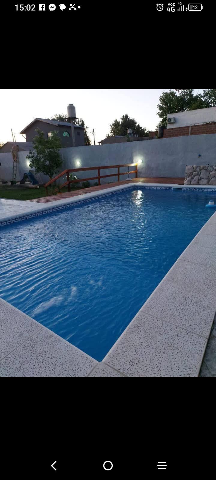 Pileta de hormigón con deck de madera construida por JM Piletas