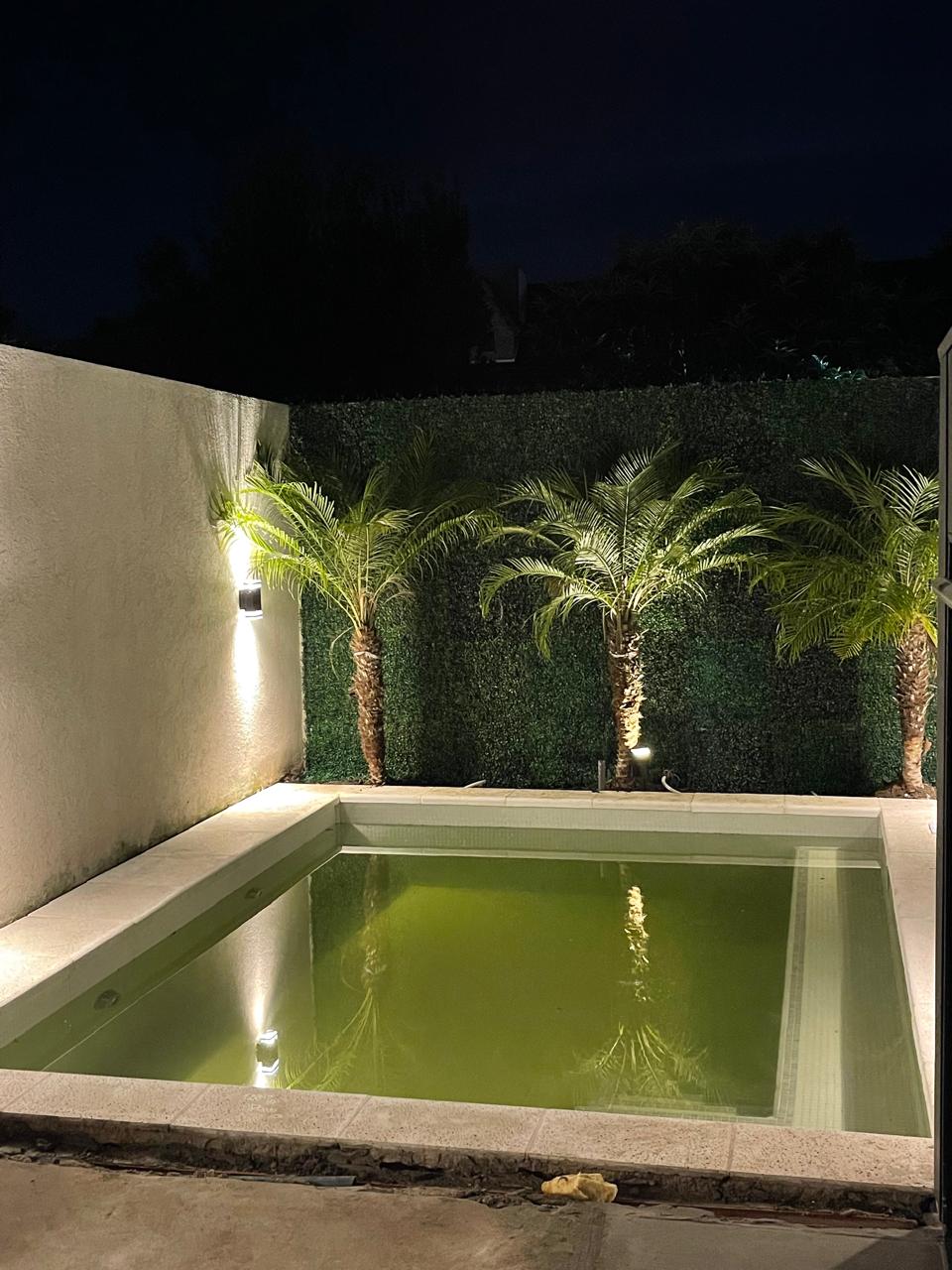 Pileta de hormigón terminada por JM Piletas con iluminación nocturna
